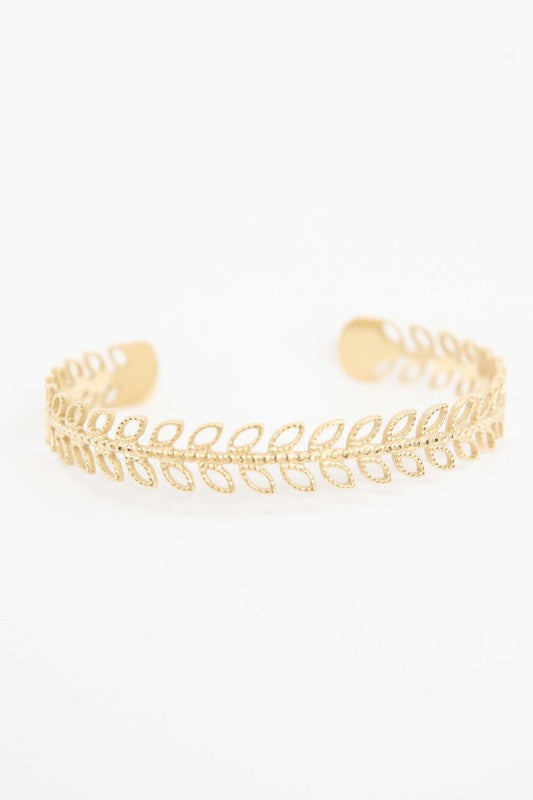 Fern cuff bracelet with 14k gold plating on a white background.