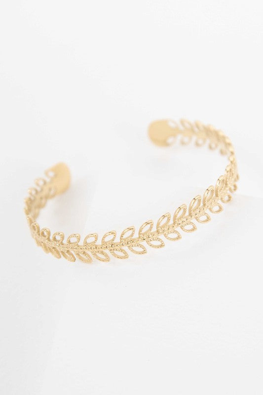 Fern cuff bracelet with 14k gold plating on a white background.