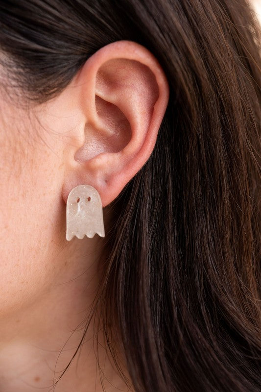 Woman wearing Ghost Studs, smiling and touching her hair.