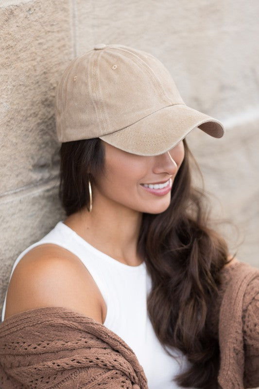 Woman in an Everyday Washed Ball Cap smiling and leaning against a wall.