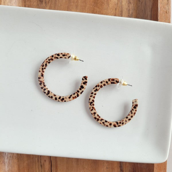 Pair of lightweight Camy Hoops - Brown Dot acrylic earrings with clear backings displayed on a white dish.