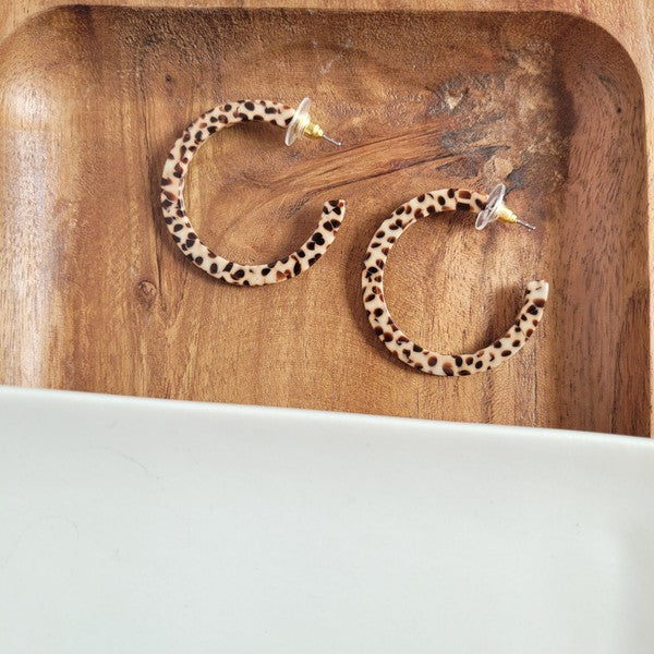 Pair of lightweight Camy Hoops - Brown Dot acrylic earrings with clear backings displayed on a white dish.