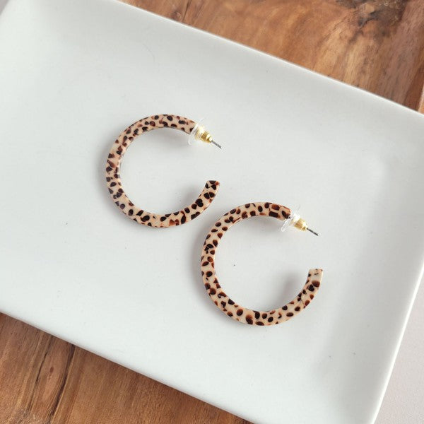 Pair of lightweight Camy Hoops - Brown Dot acrylic earrings with clear backings displayed on a white dish.