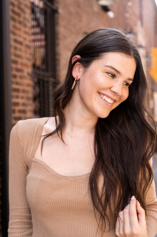 Pair of lightweight Camy Hoops - Brown Dot acrylic earrings with clear backings displayed on a white dish.