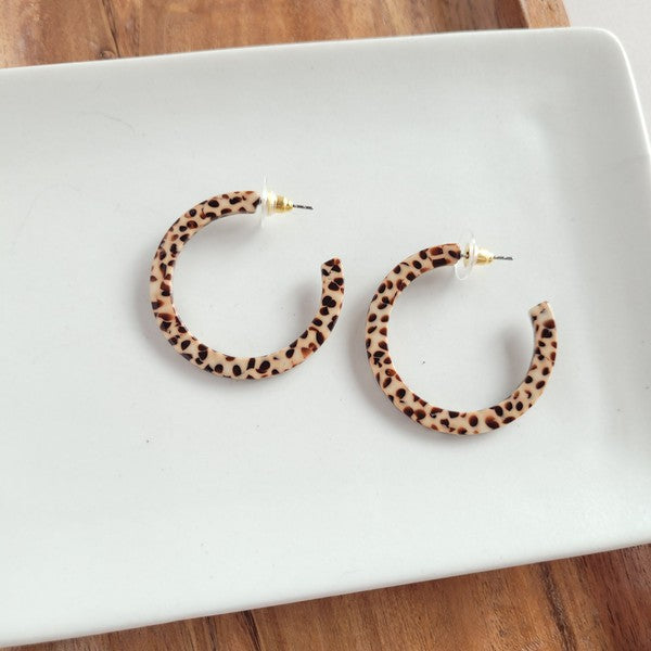 Pair of lightweight Camy Hoops - Brown Dot acrylic earrings with clear backings displayed on a white dish.