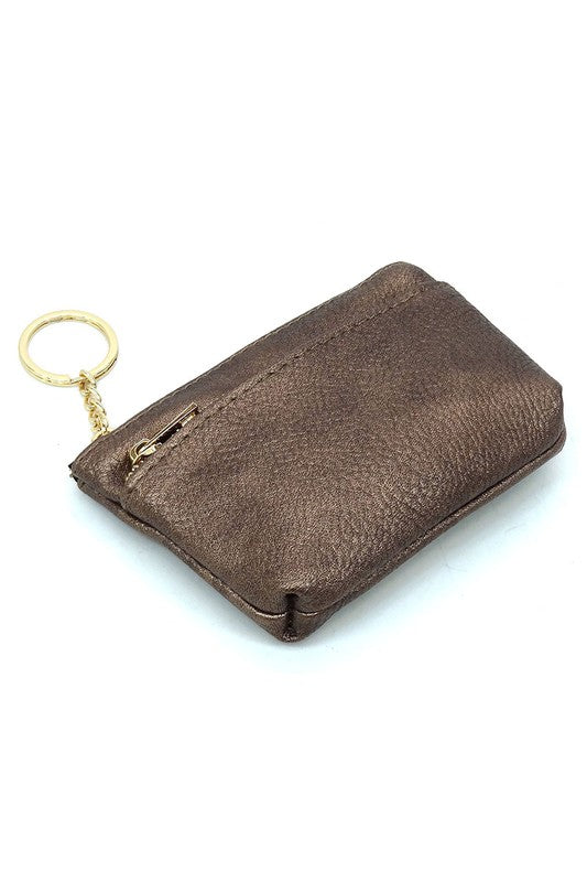 The Fashion Keychain Coin Purse is a compact, textured brown coin holder made from vegan leather. It features a zippered closure, an external pocket, and comes with an attached gold keyring.