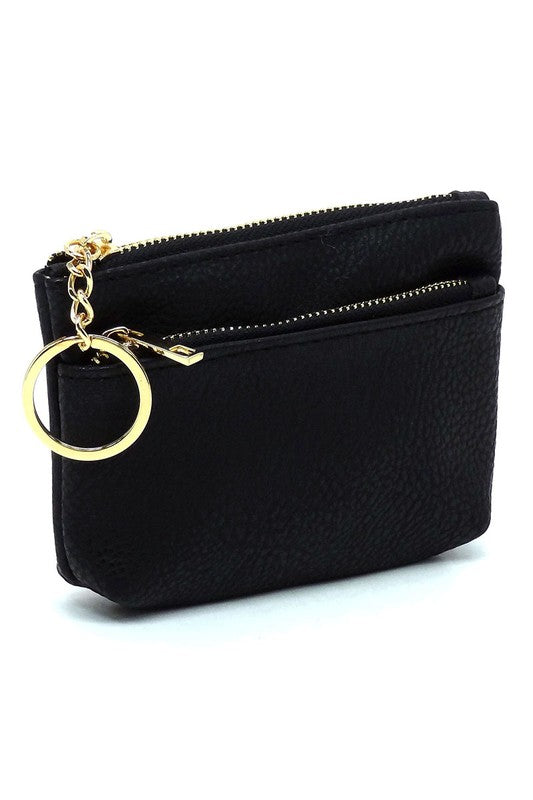 The Fashion Keychain Coin Purse is a compact, textured brown coin holder made from vegan leather. It features a zippered closure, an external pocket, and comes with an attached gold keyring.
