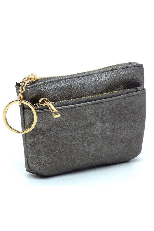 The Fashion Keychain Coin Purse is a compact, textured brown coin holder made from vegan leather. It features a zippered closure, an external pocket, and comes with an attached gold keyring.