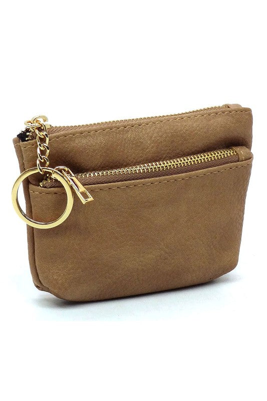 The Fashion Keychain Coin Purse is a compact, textured brown coin holder made from vegan leather. It features a zippered closure, an external pocket, and comes with an attached gold keyring.