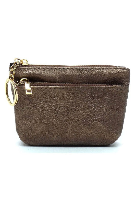 The Fashion Keychain Coin Purse is a compact, textured brown coin holder made from vegan leather. It features a zippered closure, an external pocket, and comes with an attached gold keyring.