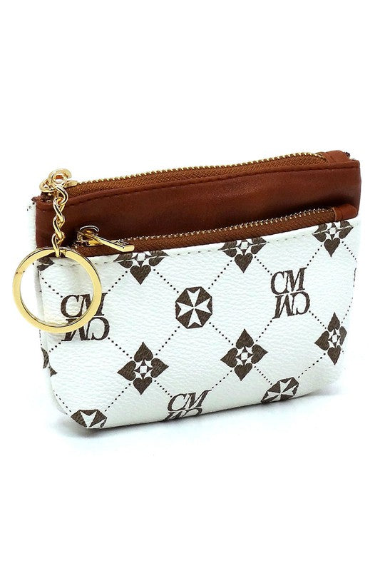 The CM Monogram Keychain Coin Purse is a small, white faux vegan leather pouch adorned with a brown geometric pattern. It features a brown zipper and comes with a gold CM Monogram keychain, along with the letters "CMWD".