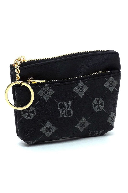 The CM Monogram Keychain Coin Purse is a small, white faux vegan leather pouch adorned with a brown geometric pattern. It features a brown zipper and comes with a gold CM Monogram keychain, along with the letters "CMWD".