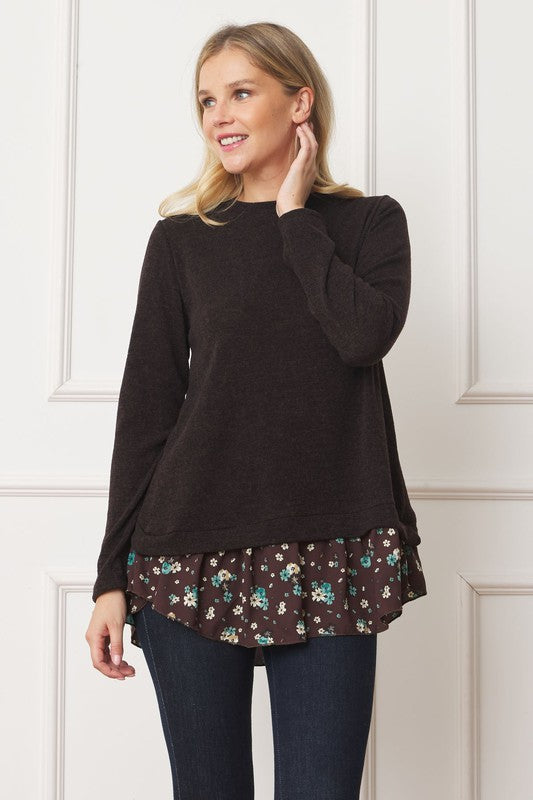A woman wearing the Layered Floral Tulip Hem Back Accent Top, a long-sleeve black top with a layered floral hem, and dark blue jeans is shown from the front and back.