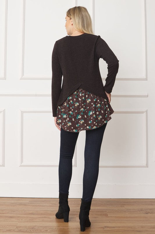 A woman wearing the Layered Floral Tulip Hem Back Accent Top, a long-sleeve black top with a layered floral hem, and dark blue jeans is shown from the front and back.