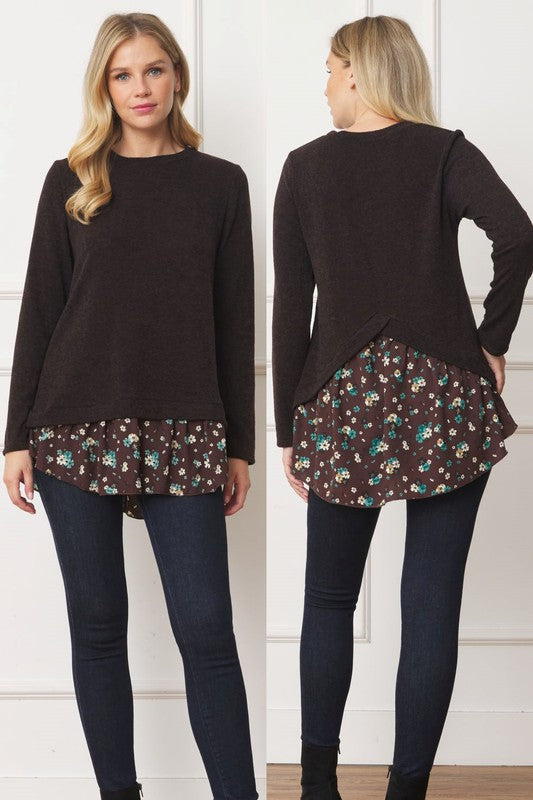 A woman wearing the Layered Floral Tulip Hem Back Accent Top, a long-sleeve black top with a layered floral hem, and dark blue jeans is shown from the front and back.