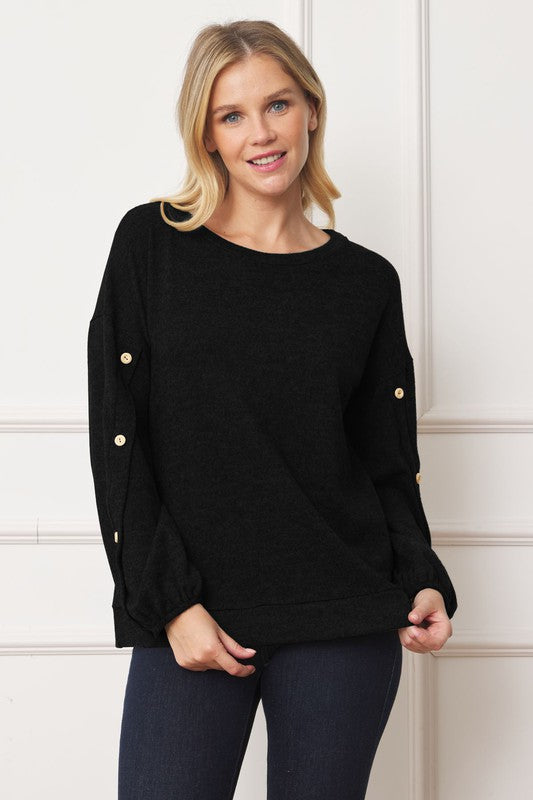 A woman is standing and smiling, wearing the Drop Shoulder Button Sleeve Detail Top in brown and dark pants.