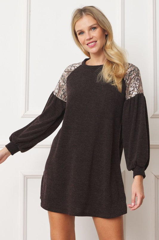 A woman stands smiling, wearing the Paisley Shoulder Accent Tunic Dress.