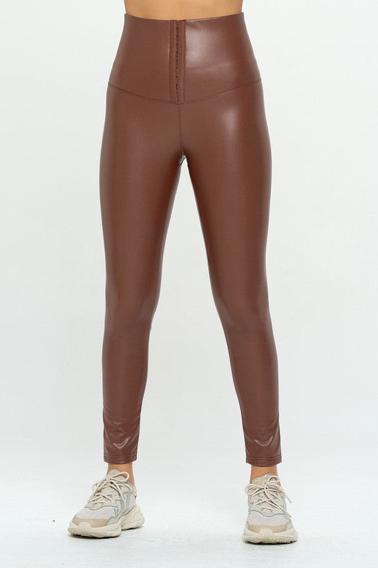 Person wearing High Waist PU Leather Corset Cincher Pants in brown with tummy control and white sneakers.