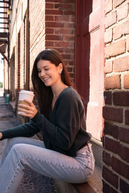 A pair of Snowflake Studs, glittery and crafted from hypoallergenic stainless steel, displayed on a wooden surface.