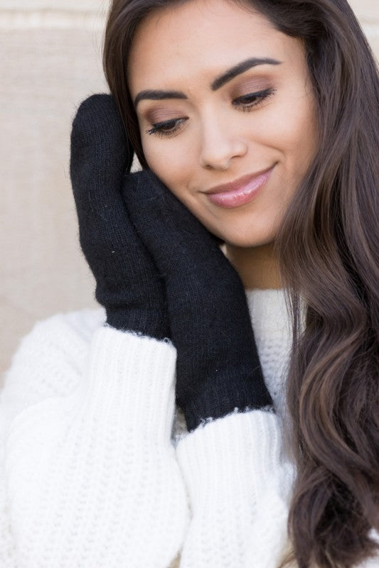 A woman in a white sweater wearing Everyday Cozy Mittens.