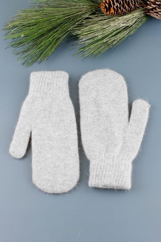 A woman in a white sweater wearing Everyday Cozy Mittens.