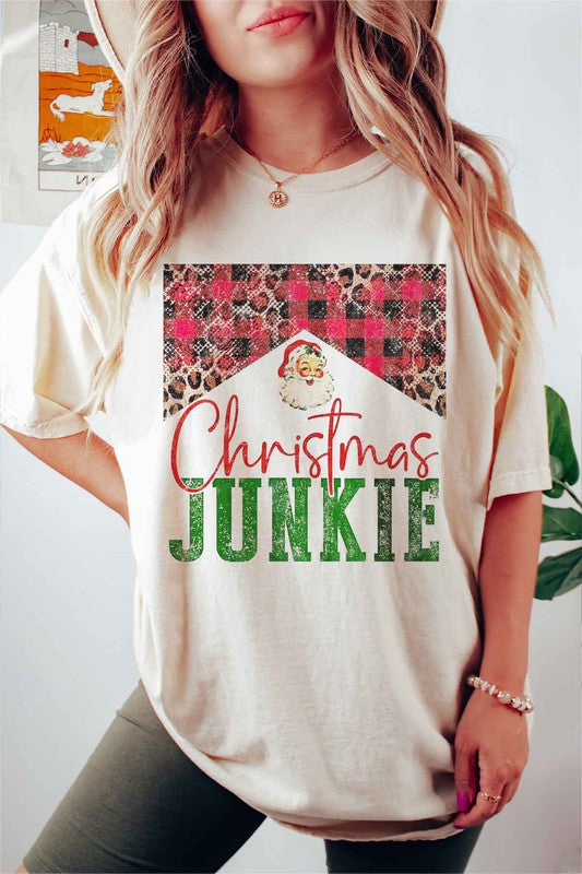 A woman wearing a CHRISTMAS JUNKIE GRAPHIC TEE / T-SHIRT that features a Santa graphic and animal print designs smiles at the camera.