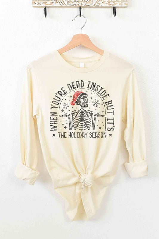 A CHRISTMAS SKELETON LONG SLEEVE TEE on a hanger, showcasing a premium cotton fabric with a Christmas skeleton in a Santa hat and the text "WHEN YOU'RE DEAD INSIDE BUT IT'S THE HOLIDAY SEASON".