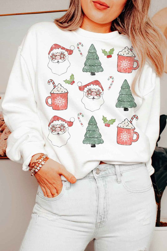 Person wearing the CHRISTMAS COLLECTION GRAPHIC SWEATSHIRT in light gray, featuring festive prints of Santa faces, hot cocoa mugs, Christmas trees, and candy canes, paired with denim shorts.