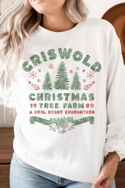 Person wearing a cozy CHRISTMAS TREE FARM GRAPHIC PLUS SIZE SWEATSHIRT in white, adorned with green and red text: "Griswold Christmas Tree Farm '89, A Real Beaut Guaranteed," showcasing festive Christmas trees and holiday decorations. Perfect for a charming visit to the Christmas tree farm!