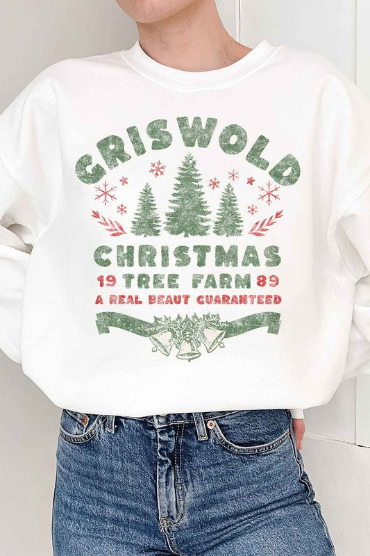 Person wearing a cozy CHRISTMAS TREE FARM GRAPHIC PLUS SIZE SWEATSHIRT in white, adorned with green and red text: "Griswold Christmas Tree Farm '89, A Real Beaut Guaranteed," showcasing festive Christmas trees and holiday decorations. Perfect for a charming visit to the Christmas tree farm!