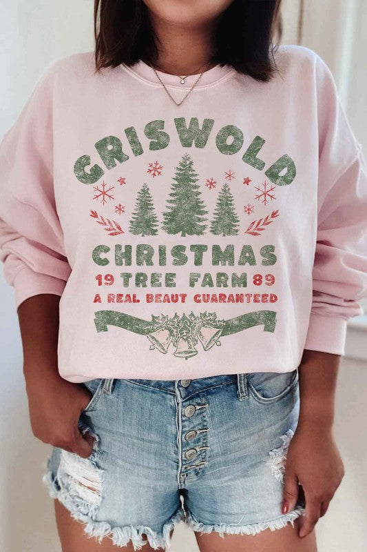 Person wearing a cozy CHRISTMAS TREE FARM GRAPHIC PLUS SIZE SWEATSHIRT in white, adorned with green and red text: "Griswold Christmas Tree Farm '89, A Real Beaut Guaranteed," showcasing festive Christmas trees and holiday decorations. Perfect for a charming visit to the Christmas tree farm!