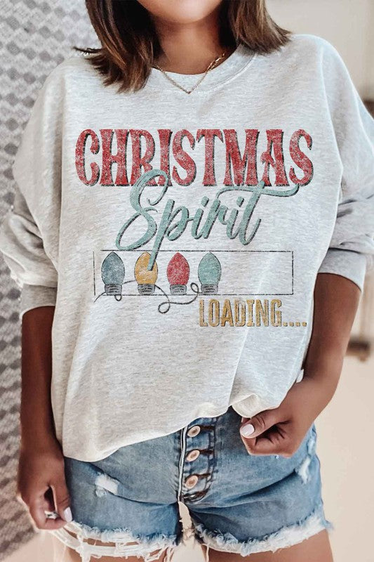 Person wearing the Loading Christmas Spirit Graphic Sweatshirt, featuring the text "Christmas Spirit Loading..." and colorful Christmas lights, perfect for your holiday wardrobe. Unisex sizing ensures a comfortable fit for everyone.