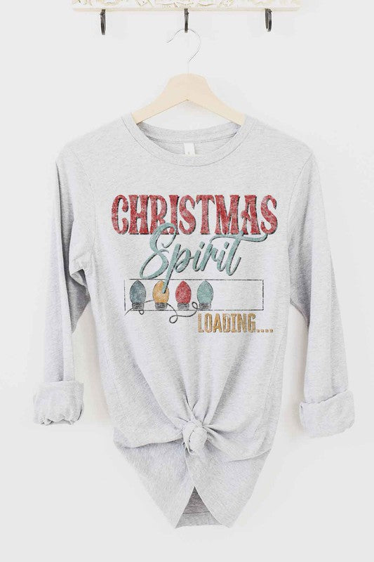 White long-sleeve CHRISTMAS TREE FARM tee on a wooden hanger with the text "Christmas Spirit Loading..." and images of Christmas lights. This premium cotton shirt features a front tie knot, perfect for adding festive flair to your holiday wardrobe.