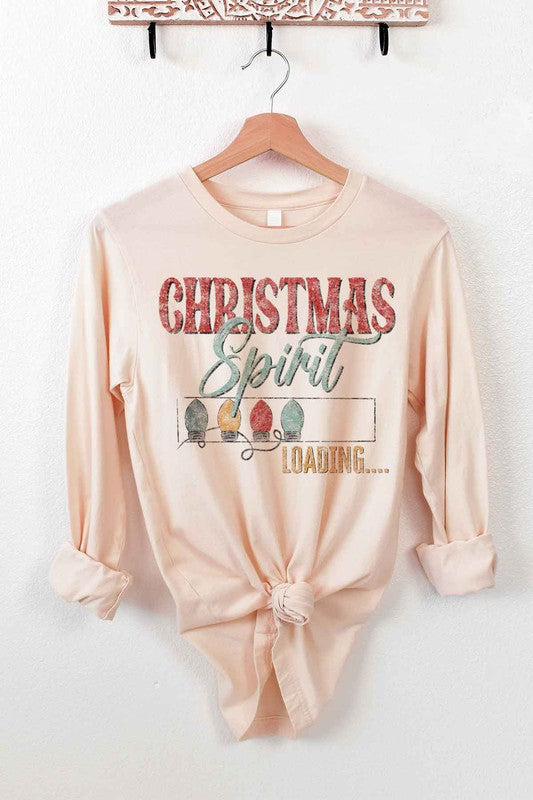 White long-sleeve CHRISTMAS TREE FARM tee on a wooden hanger with the text "Christmas Spirit Loading..." and images of Christmas lights. This premium cotton shirt features a front tie knot, perfect for adding festive flair to your holiday wardrobe.