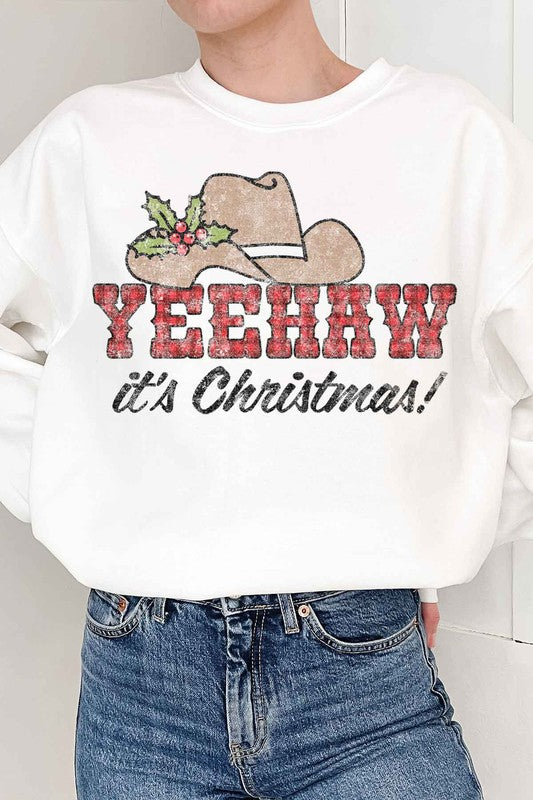 Person wearing the Yeehaw Country Christmas Graphic Sweatshirt with a cowboy hat and holly, the text "YEEHAW it's Christmas!" — perfect for anyone embracing holiday fashion.