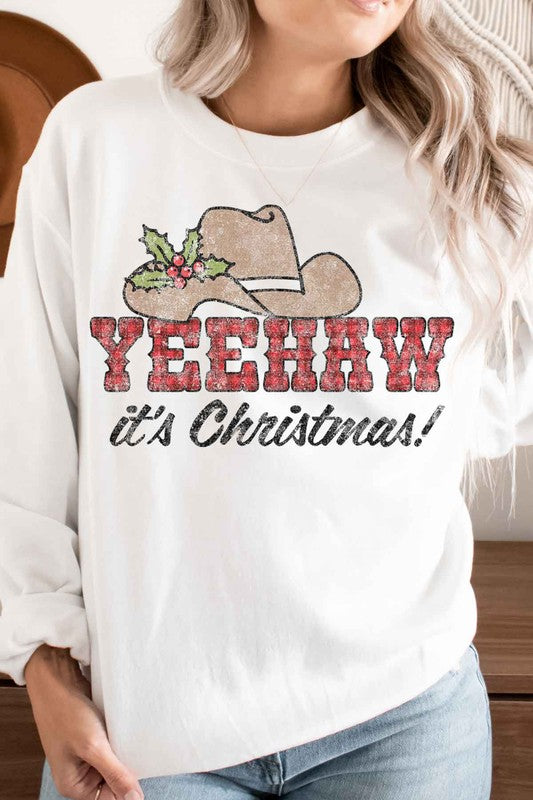 Person wearing the Yeehaw Country Christmas Graphic Sweatshirt with a cowboy hat and holly, the text "YEEHAW it's Christmas!" — perfect for anyone embracing holiday fashion.