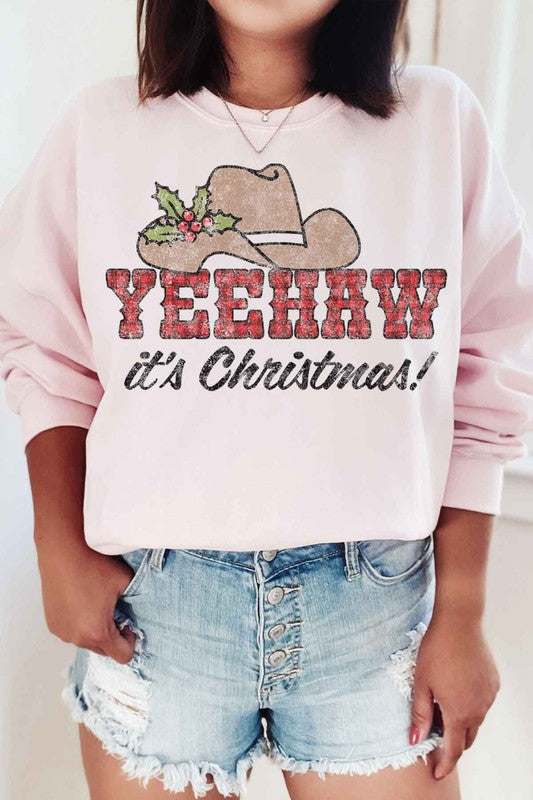 Individual dressed in a YEEHAW COUNTRY CHRISTMAS PLUS SIZE SWEATSHIRT, featuring a cowboy hat and holly graphic, along with the phrase "YEEHAW it's Christmas!" written on it.