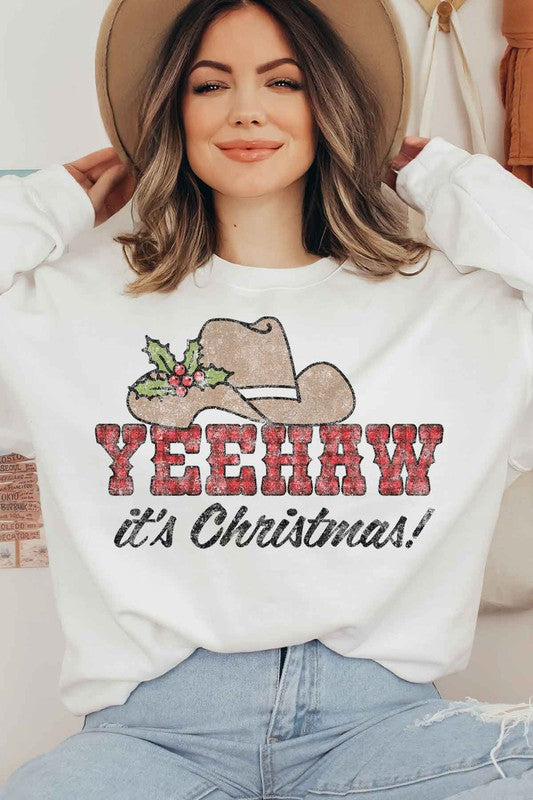 Individual dressed in a YEEHAW COUNTRY CHRISTMAS PLUS SIZE SWEATSHIRT, featuring a cowboy hat and holly graphic, along with the phrase "YEEHAW it's Christmas!" written on it.