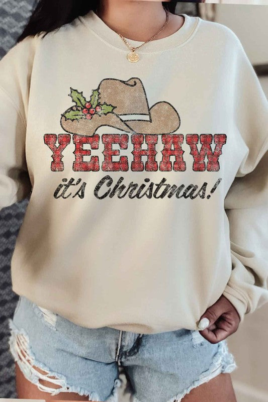 Individual dressed in a YEEHAW COUNTRY CHRISTMAS PLUS SIZE SWEATSHIRT, featuring a cowboy hat and holly graphic, along with the phrase "YEEHAW it's Christmas!" written on it.