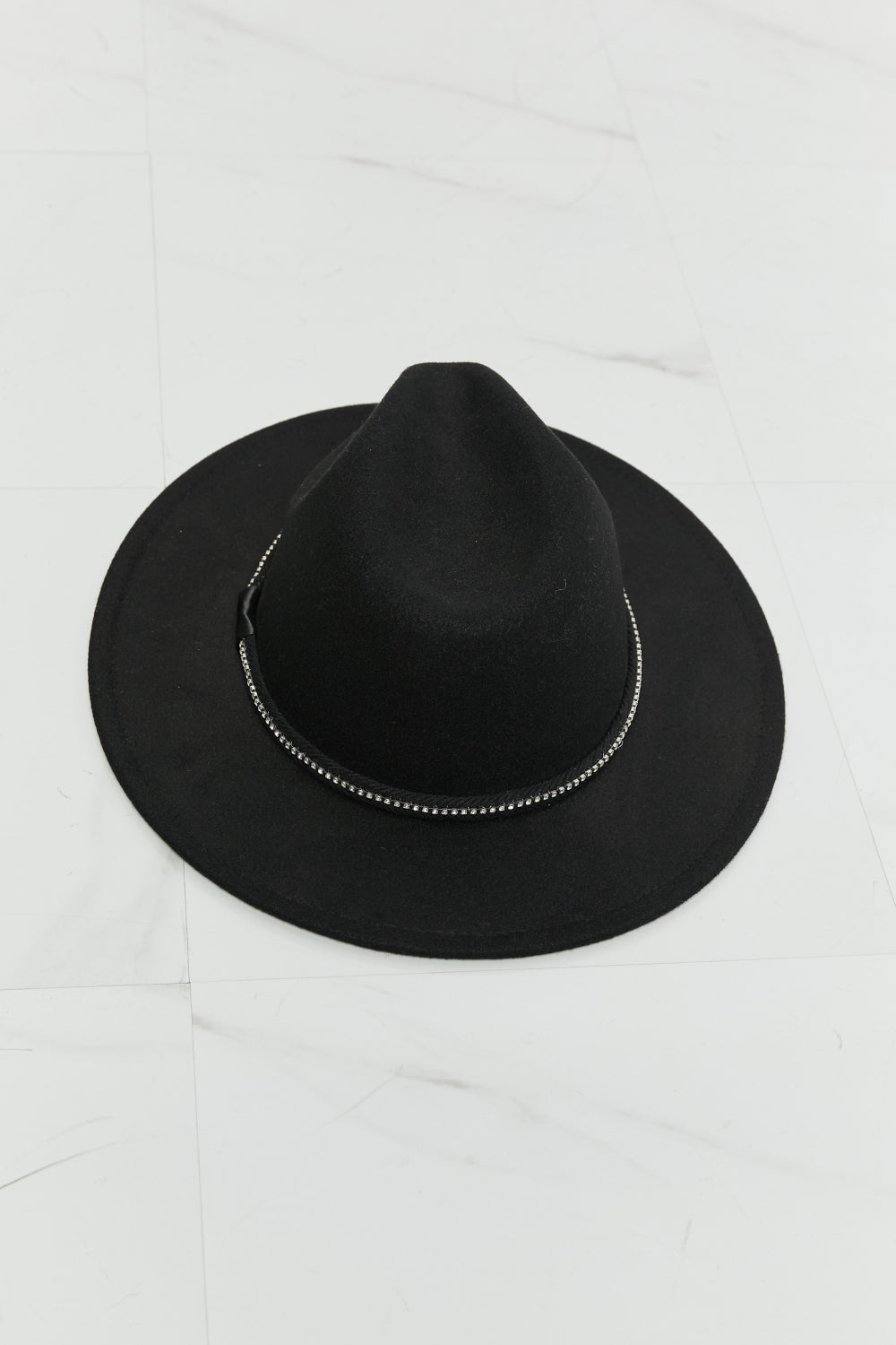 Person with long wavy hair wearing the Fame Bring It Back Fedora Hat, which features a black wide brim and rhinestone detailing, paired with a white tank top, viewed from the back.