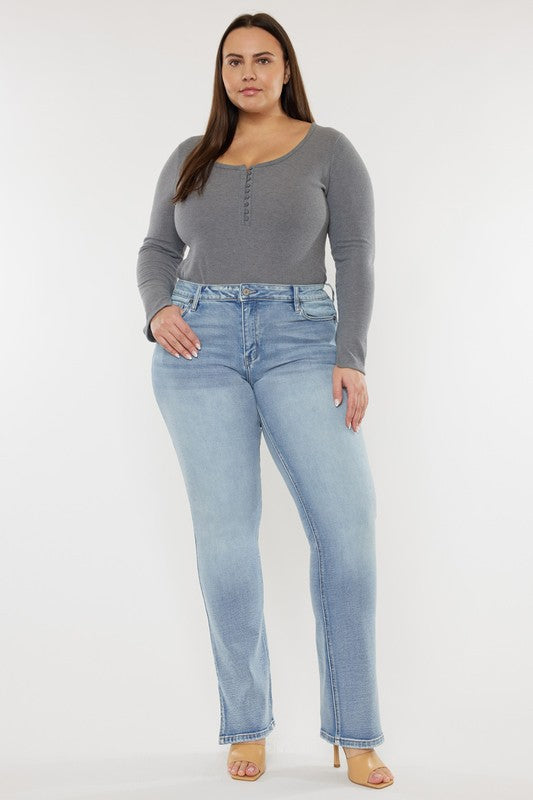 A person wearing a grey long-sleeve top and Plus Mid Rise Y2K Medium Wash Bootcut Jeans poses against a plain white background.