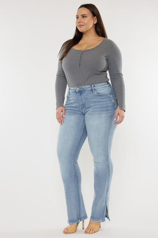 A person wearing a grey long-sleeve top and Plus Mid Rise Y2K Medium Wash Bootcut Jeans poses against a plain white background.