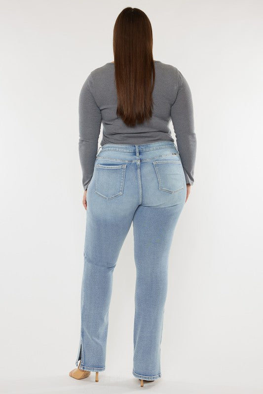 A person wearing a grey long-sleeve top and Plus Mid Rise Y2K Medium Wash Bootcut Jeans poses against a plain white background.