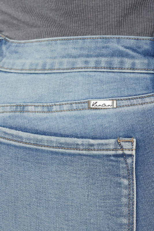 A person wearing a grey long-sleeve top and Plus Mid Rise Y2K Medium Wash Bootcut Jeans poses against a plain white background.