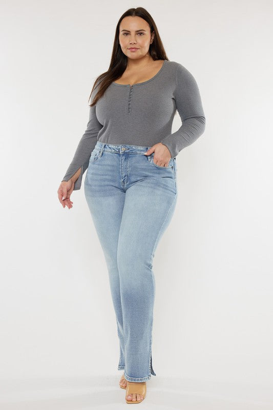 A person wearing a grey long-sleeve top and Plus Mid Rise Y2K Medium Wash Bootcut Jeans poses against a plain white background.