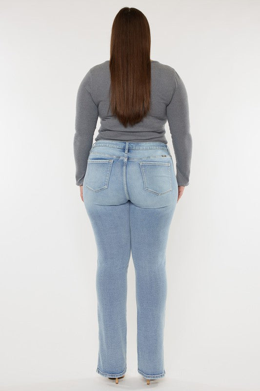 A person wearing a grey long-sleeve top and Plus Mid Rise Y2K Medium Wash Bootcut Jeans poses against a plain white background.