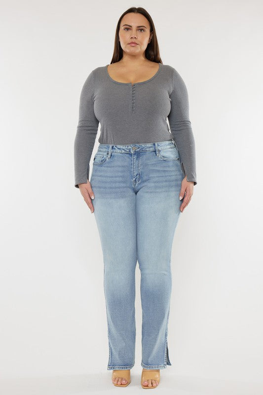 A person wearing a grey long-sleeve top and Plus Mid Rise Y2K Medium Wash Bootcut Jeans poses against a plain white background.