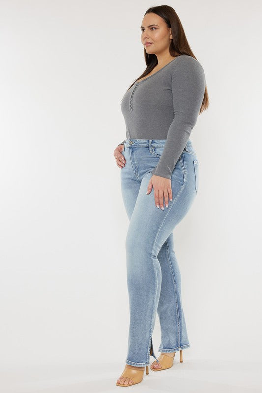 A person wearing a grey long-sleeve top and Plus Mid Rise Y2K Medium Wash Bootcut Jeans poses against a plain white background.