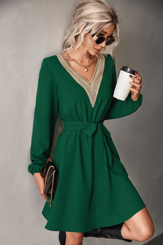 A person in sunglasses is wearing a Women's Long Sleeve V Neck Mid Dress in green, holding a coffee cup.