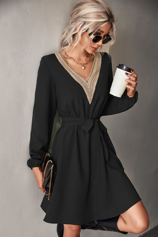 A person in sunglasses is wearing a Women's Long Sleeve V Neck Mid Dress in green, holding a coffee cup.